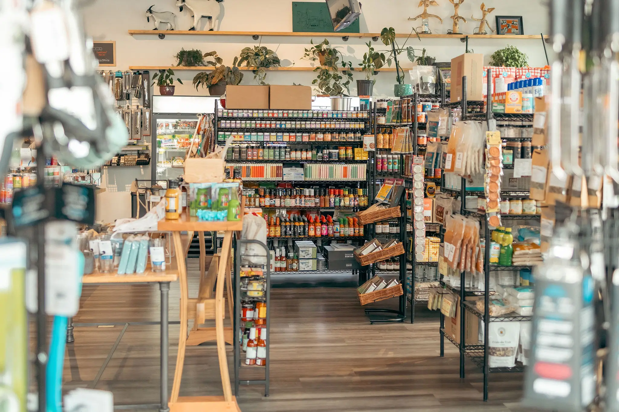 Interior view of Goat Hill World Market showcasing shelves filled with gourmet foods, sauces, and kitchenware, emphasizing the shop's curated selection and inviting atmosphere.
