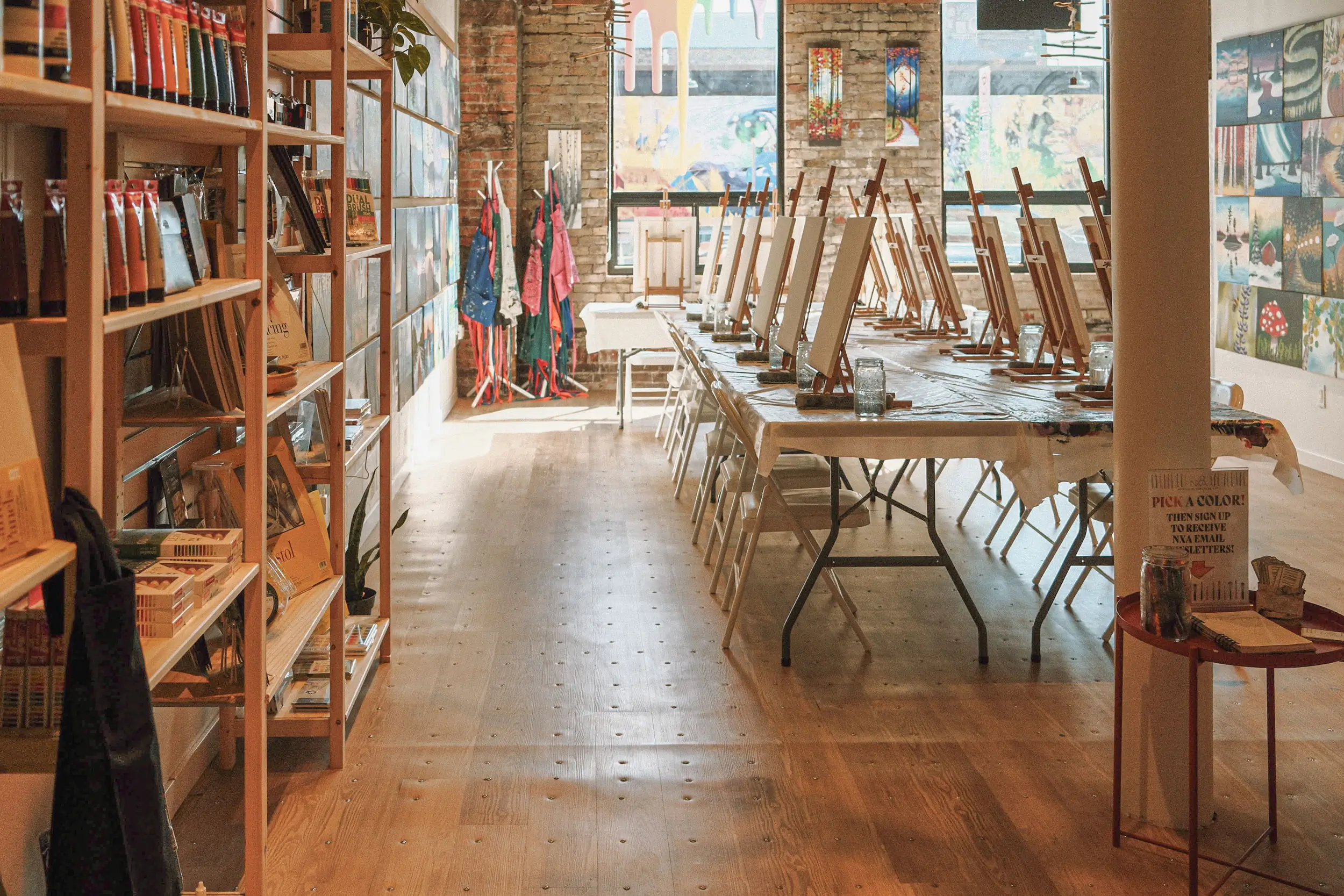 Art studio interior with easels, art supplies on shelves, and colorful artwork on walls, reflecting Northern Exposure Art's creative space for classes and community engagement in Duluth.
